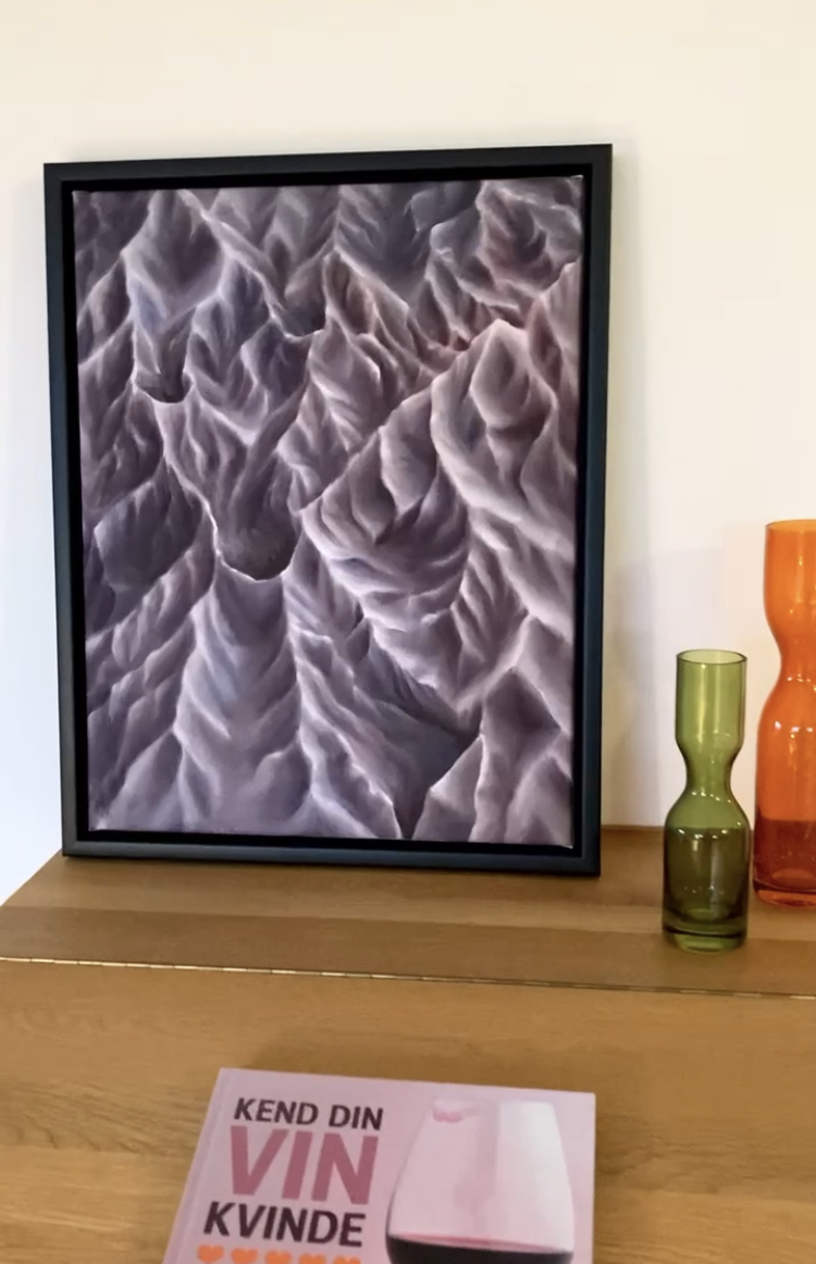 Lilla, rødbrunt maleri af former stående på kommode.