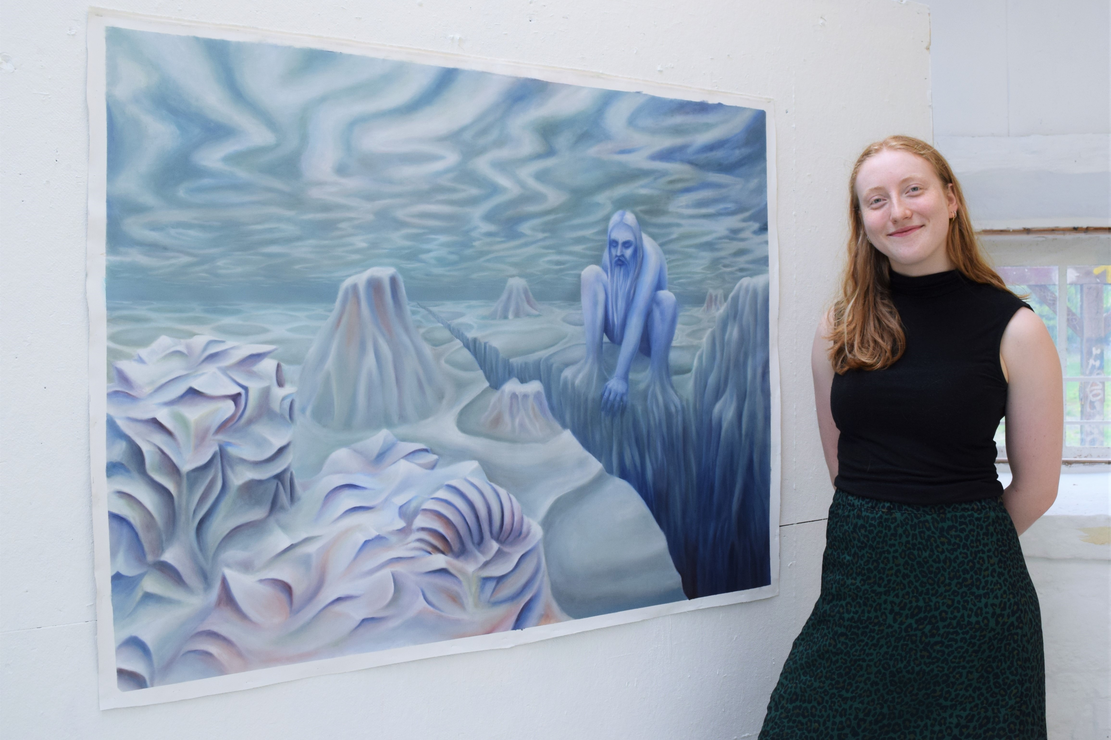 Marie Juhl står og smiler sammen med hendes første store oliemaleri.